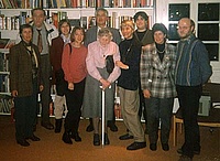 Gruppenbild der Familie vor einer Bücherwand. Zehn erwachsene Personen, zum Teil im Seniorenalter.